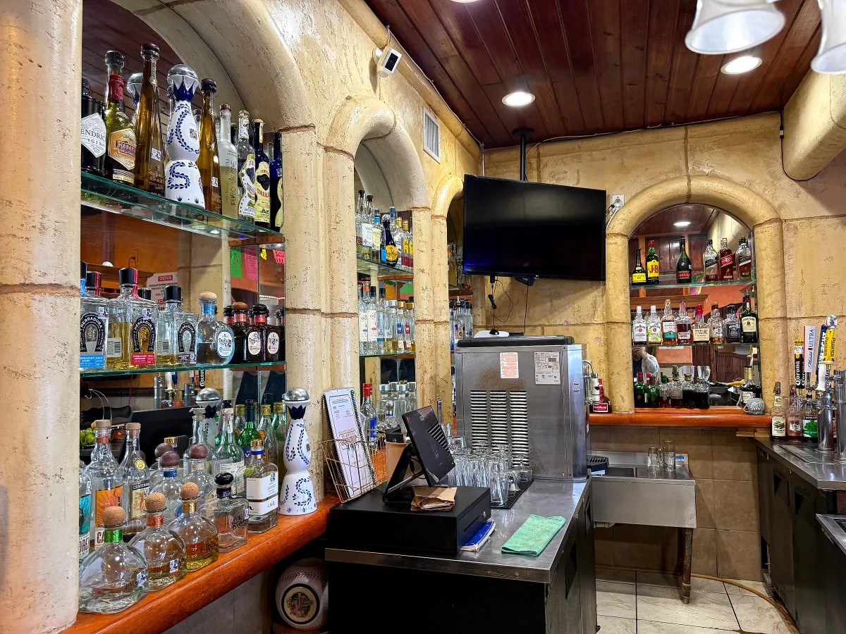 Jimador's bar: shelves of tequila behind stone arches